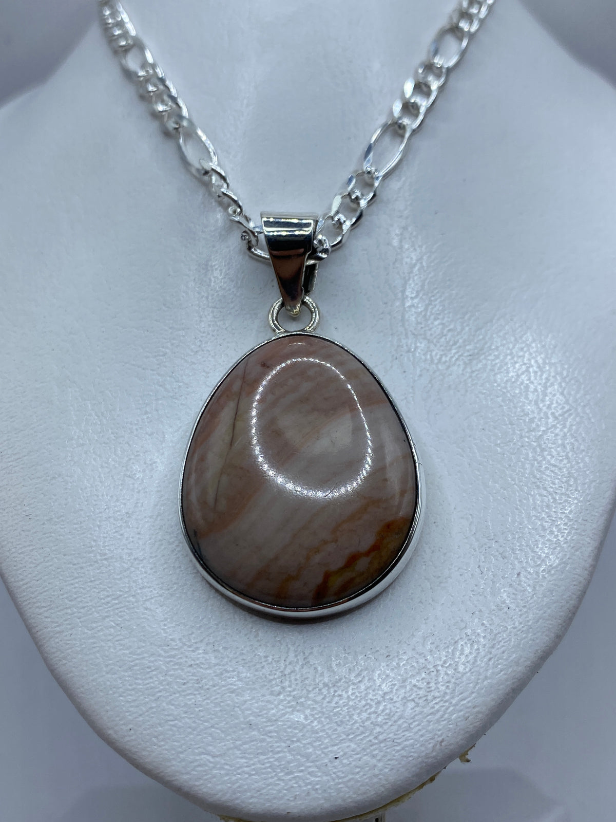 Detalle de la incrustación de piedra a mano en el dije de plata .950