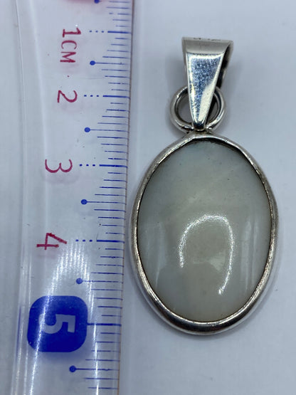 Reverso del dije de plata .950 mostrando el acabado pulido y el Quinto