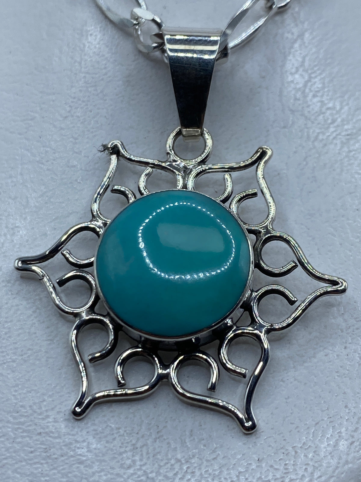 Dije de plata .950 con turquesa azul cielo engastada en marco ornamental de Taxco