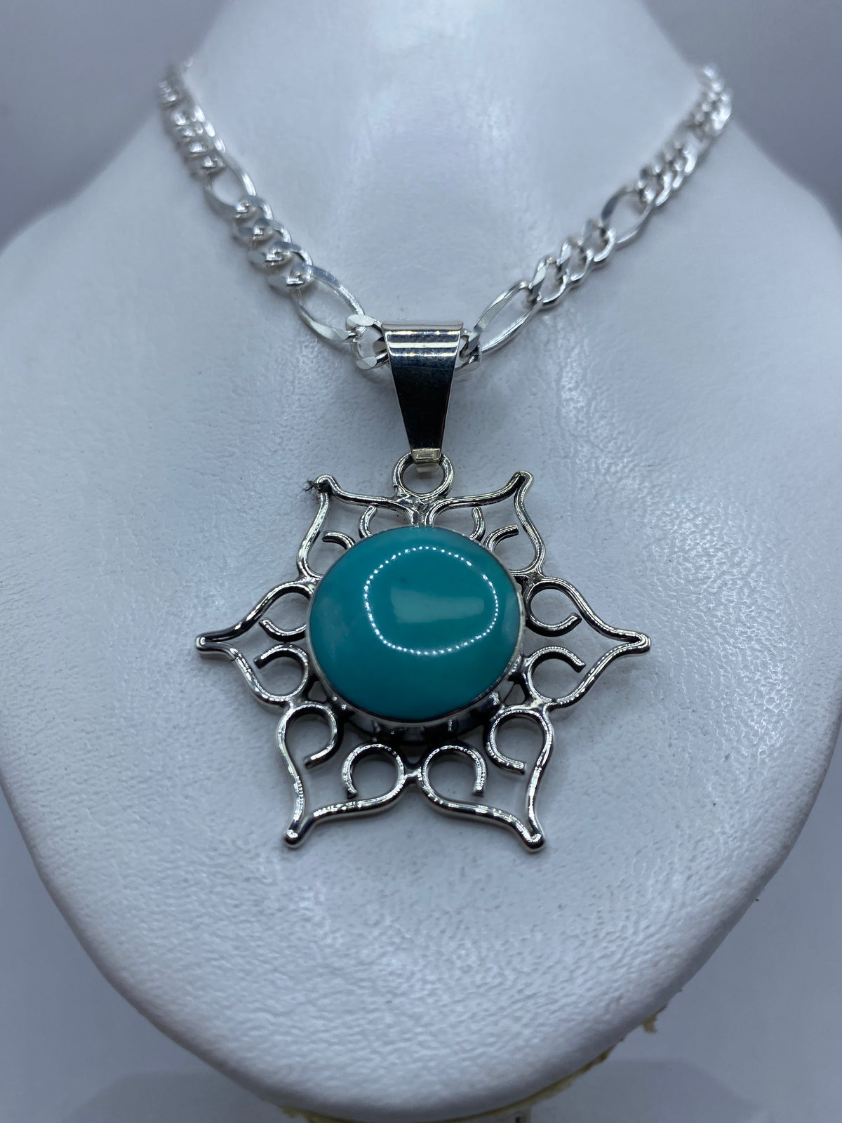 Detalle frontal del dije mostrando la turquesa azul cielo y el engaste a mano
