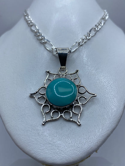 Detalle frontal del dije mostrando la turquesa azul cielo y el engaste a mano