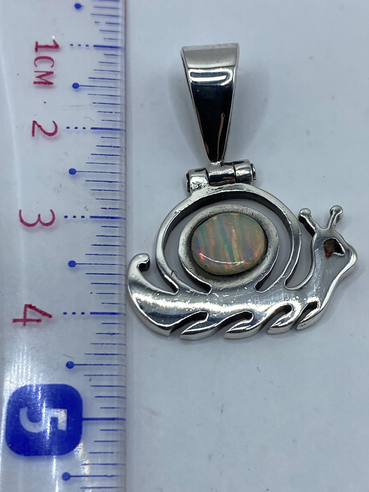 Dije de 4 cm sobre regla — tamaño discreto pero visible al cuello