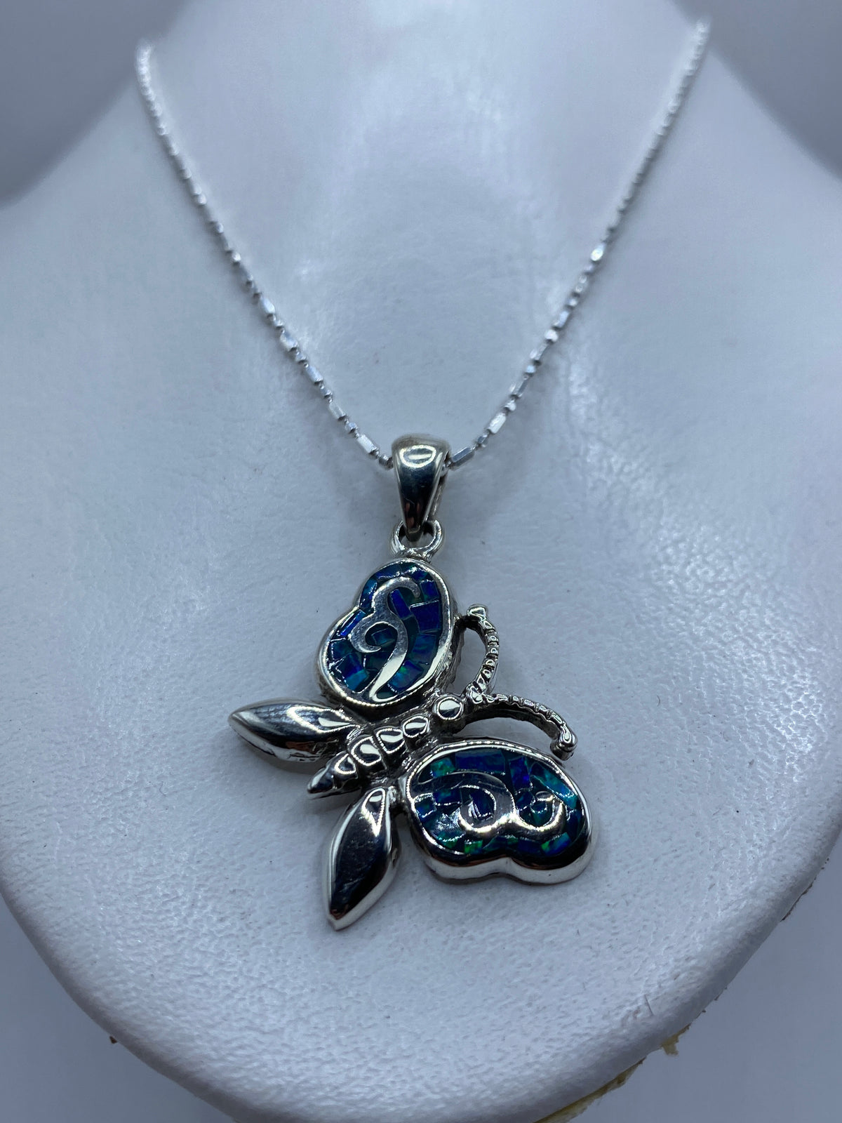 Detalle del ópalo de fuego azul brillando en el engaste de plata .950