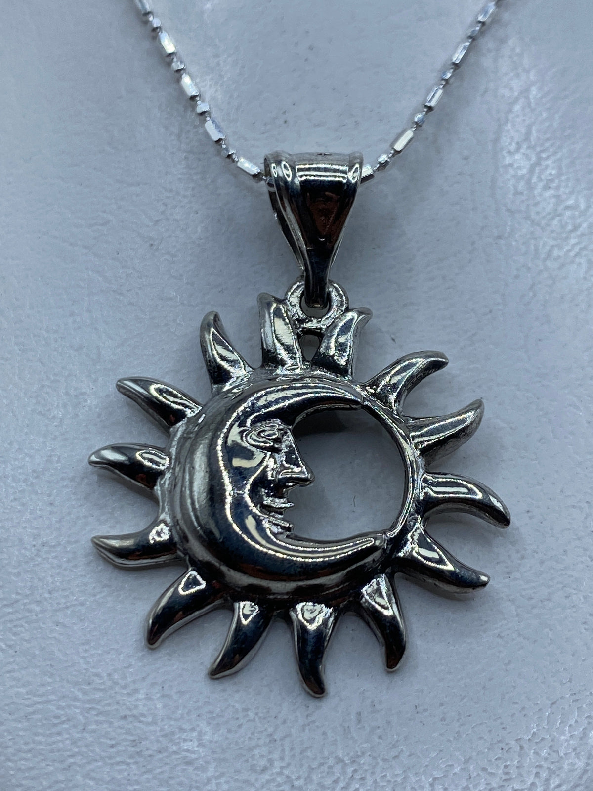 Dije de plata .925 con diseño sol y luna entrelazados, calado, 4.5 cm sobre cadena delgada