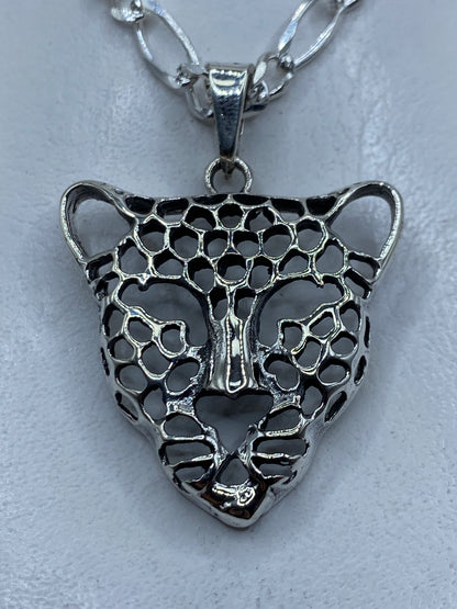 Dije de plata .925 con cabeza de jaguar en técnica de calado, mostrando el diseño en negativo