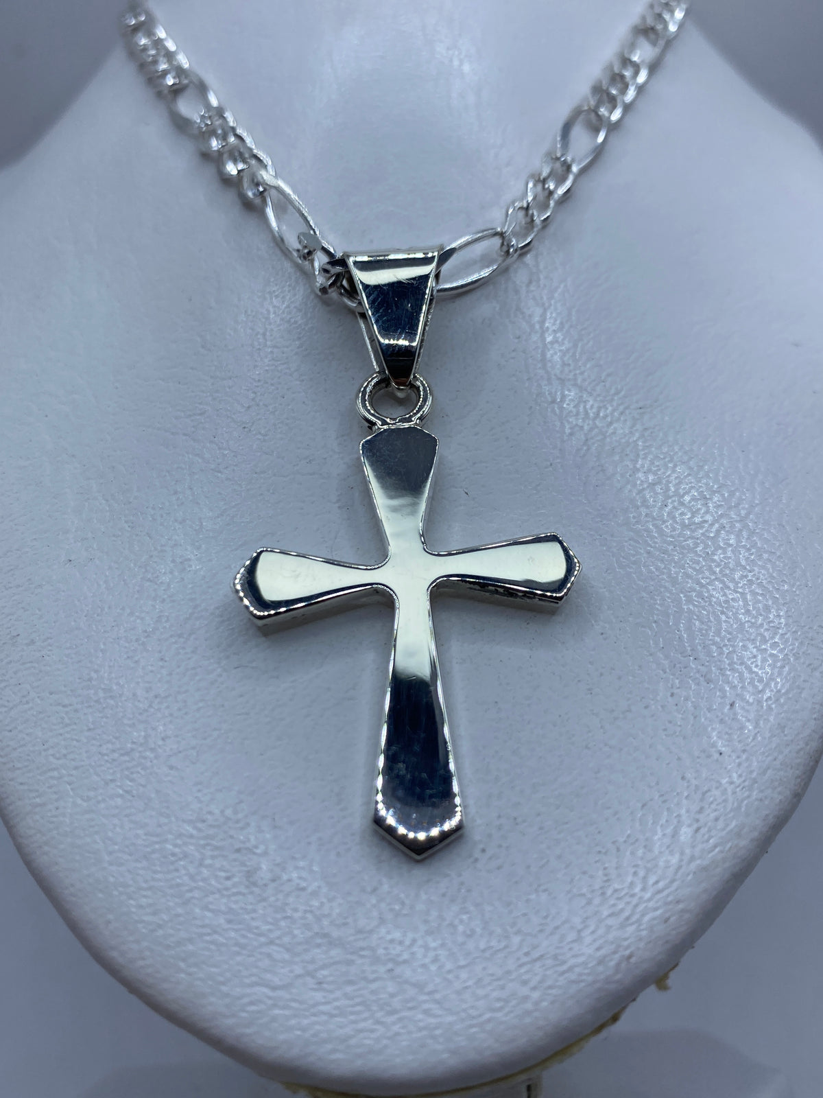 Cruz de plata de Taxco en la mano, mostrando el tamaño real de 5.7 cm