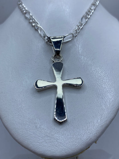 Cruz de plata de Taxco en la mano, mostrando el tamaño real de 5.7 cm