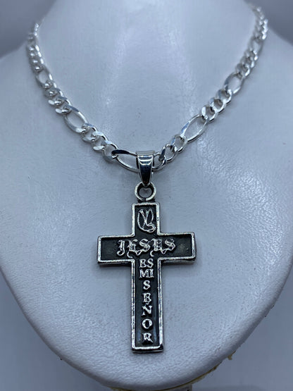 Vista frontal de la cruz de plata, diseño religioso con letras grabadas