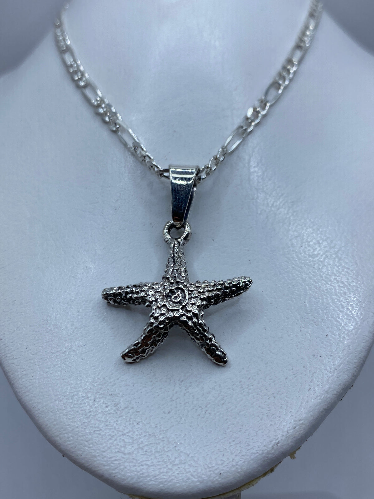 Estrella de mar de plata .925 en técnica de granulado, vista frontal sobre fondo blanco