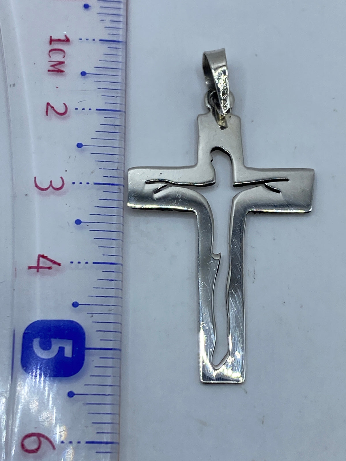 Dije cruz de plata pura visto de frente, acabado brillante, con Quinto 925 grabado