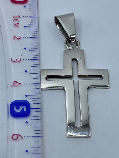Dije cruz de 6 cm en la mano, proporción real con escala