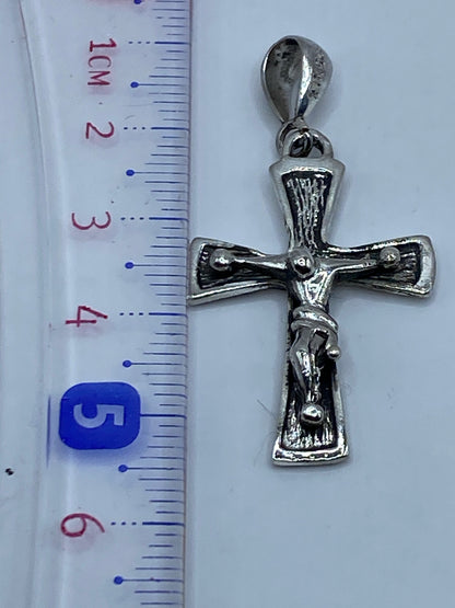 Escala: dije cruz de 5.2 cm al lado de regla métrica