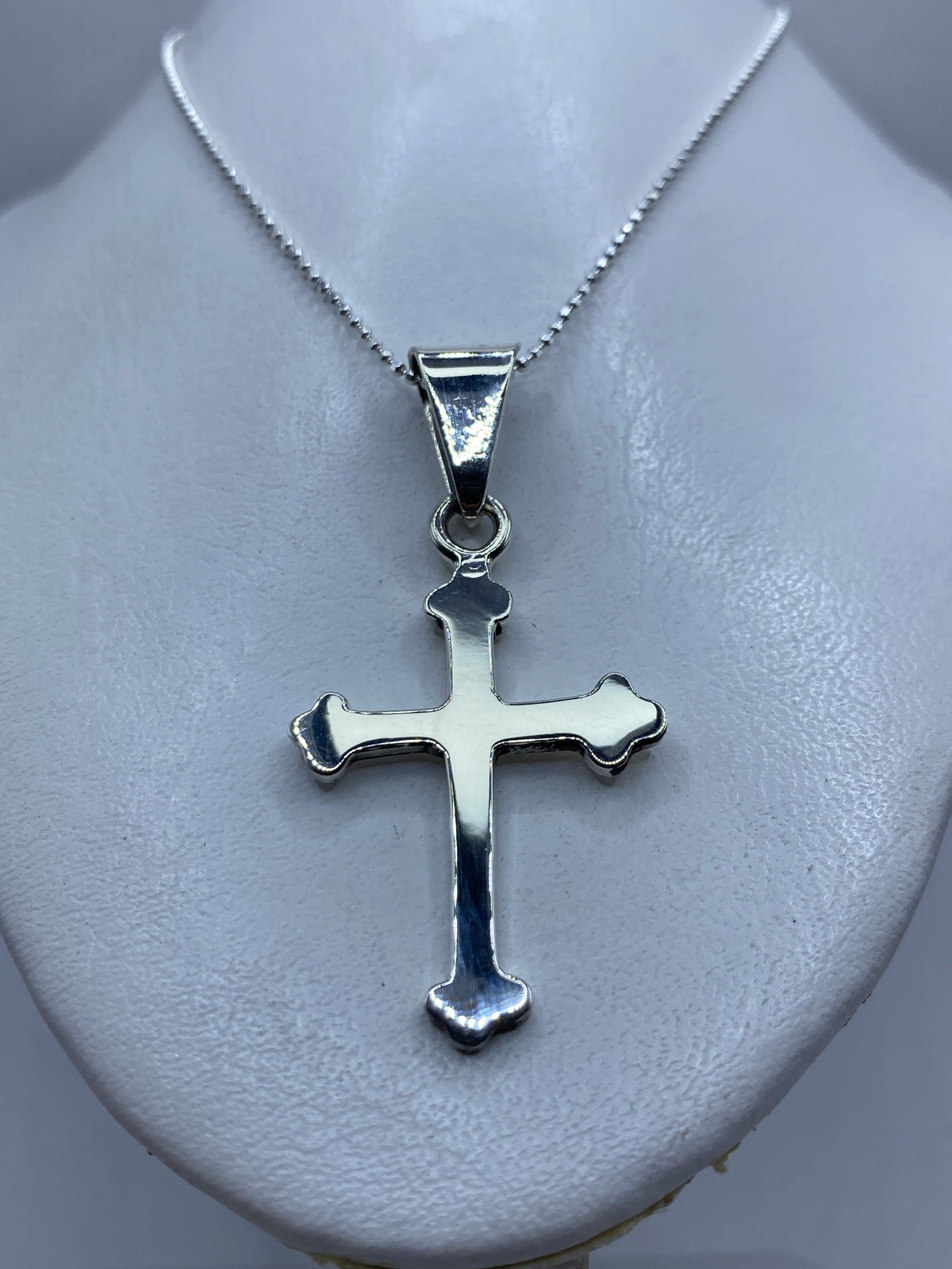 Cruz de plata Taxco con Quinto 925 colgada en collar sobre pecho