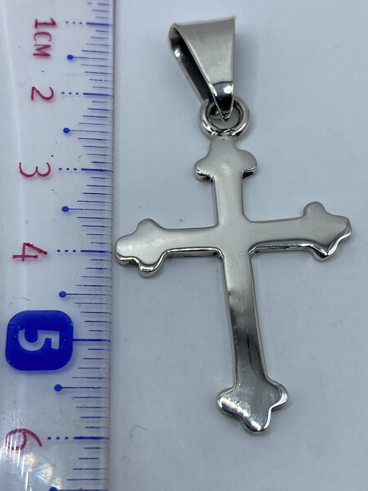 Cruz de plata sobre fondo gris mostrando el Quinto .925 y el peso 4.5 g