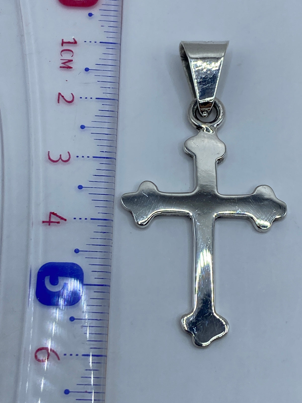 Cruz de plata .925 sobre escala de peso mostrando 5 gramos exactos