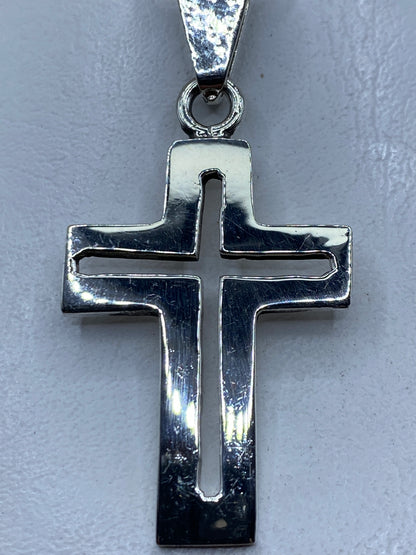 Dije cruz de plata .925 en calado colgando en cadena sobre piel