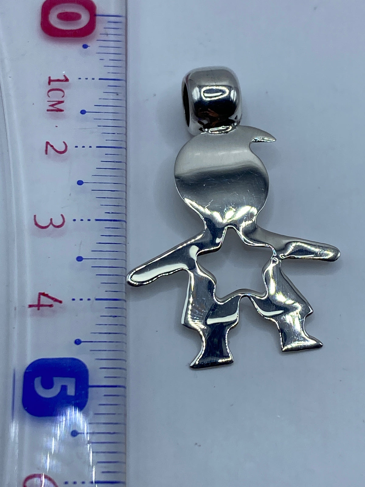Dije sobre fondo blanco mostrando el Quinto .925 grabado en el reverso