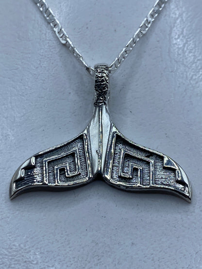 Dije de plata repujado con diseño de cola de ballena prehispánica, largo 3.5 cm