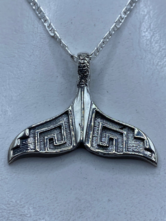 Dije de plata repujado con diseño de cola de ballena prehispánica, largo 3.5 cm