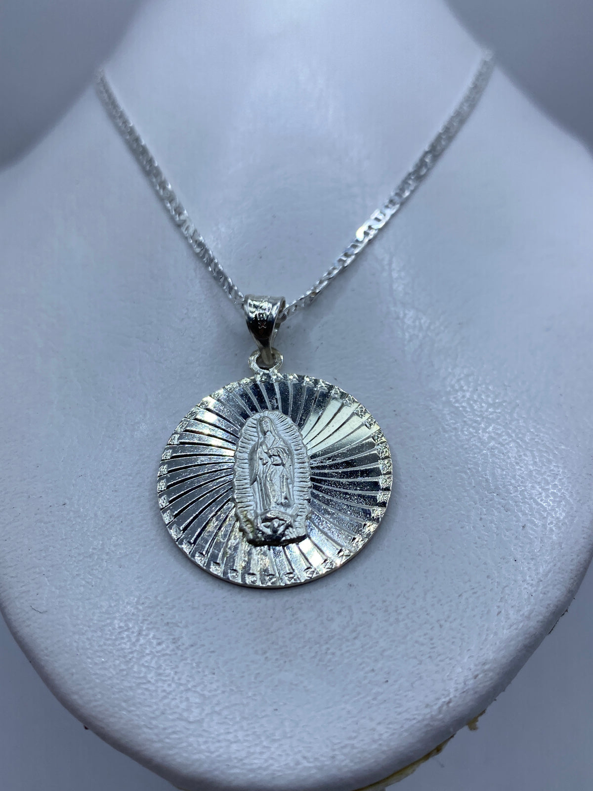 Dije de plata Virgen de Guadalupe midiendo 4.1 cm con escala de centímetros