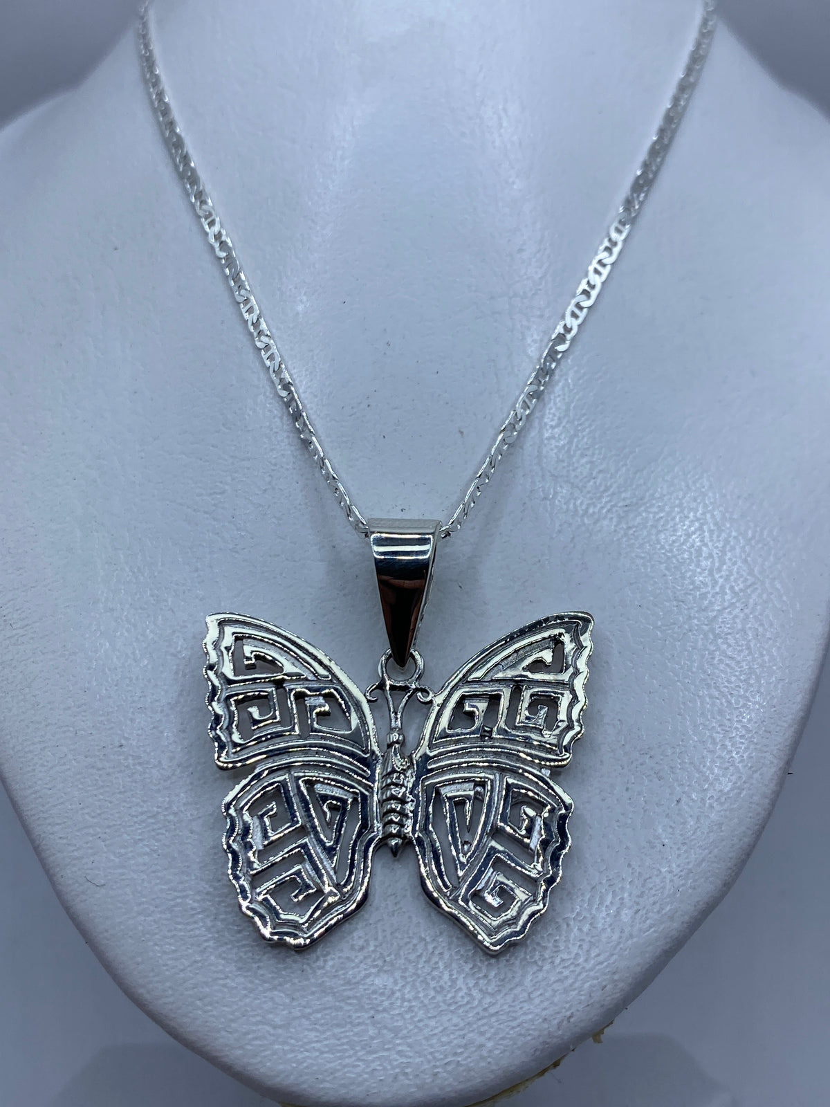 Detalle del calado preciso en las alas de la mariposa de plata