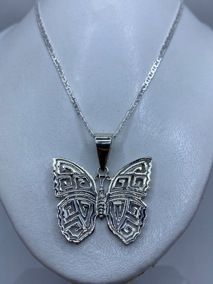 Detalle del calado preciso en las alas de la mariposa de plata