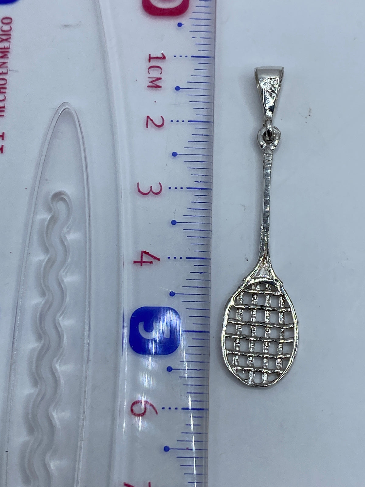 Dije de raqueta en plata .925 de Taxco pesando 1.4 gramos