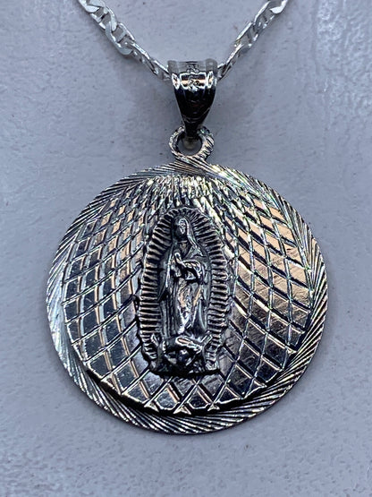 Dije de plata repujado con la Virgen de Guadalupe en relieve, 4 cm, sobre cadena plateada