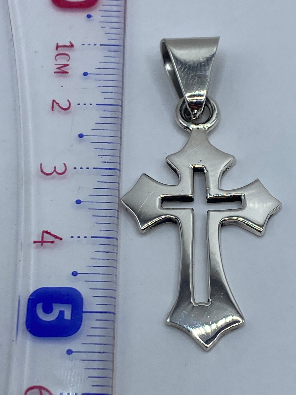 Detalle del peso y medidas del dije cruz: 4.2 gramos, 5.5 cm de largo