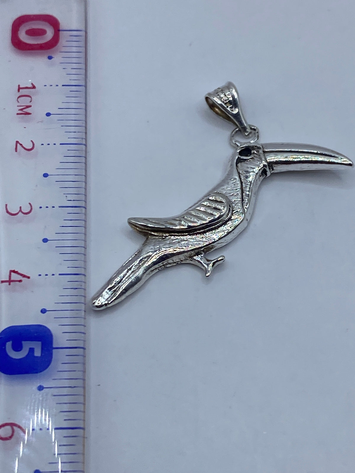 Dije colibrí sobre regla de medición: 5 centímetros exactos