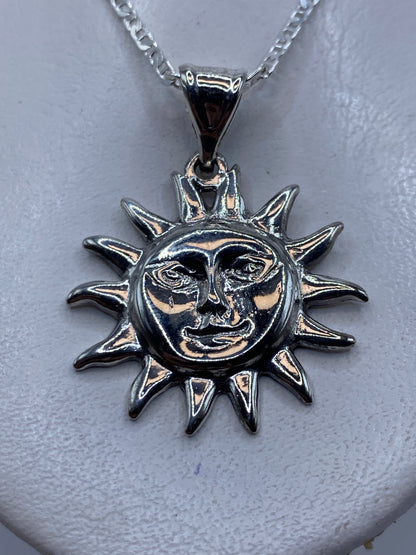 Dije de plata .925 en forma de sol sonriente con rayas puntiagudas, colgado de cadena plata en el pecho