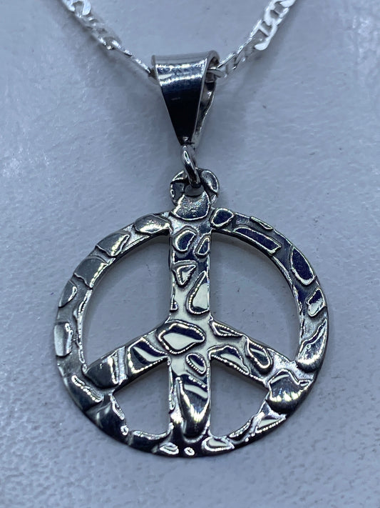 Dije símbolo de paz calado en plata .925 sobre fondo blanco