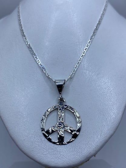 Dije de paz en plata .925 con medida de 4.3 cm junto a regla para referencia de tamaño