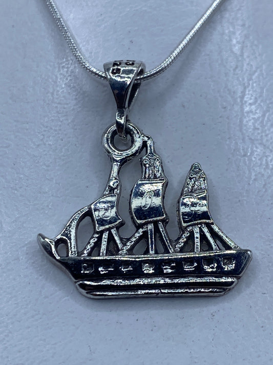 Dije de plata calado en forma de velero de tres velas, colgando de cadena de plata