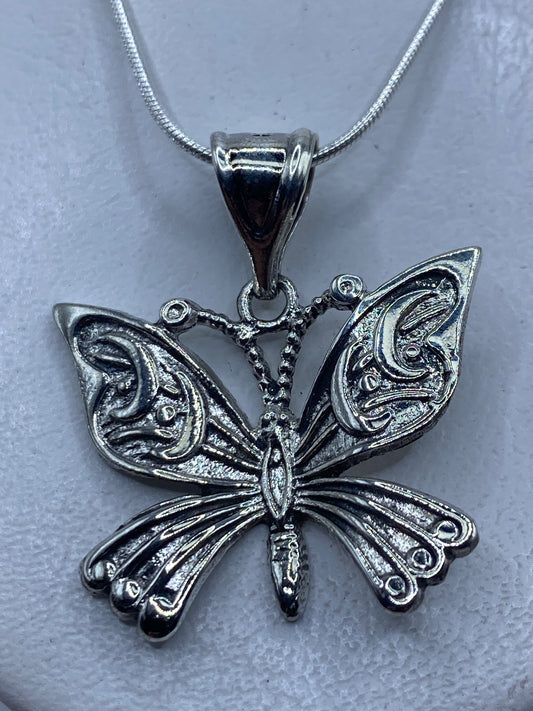Dije de mariposa en plata repujada, 4 cm de largo, colgando de una cadena fina