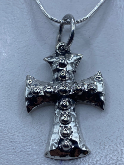 Dije de cruz en plata .925 con esferas de granulado de Taxco, colgando de una cadena plateada