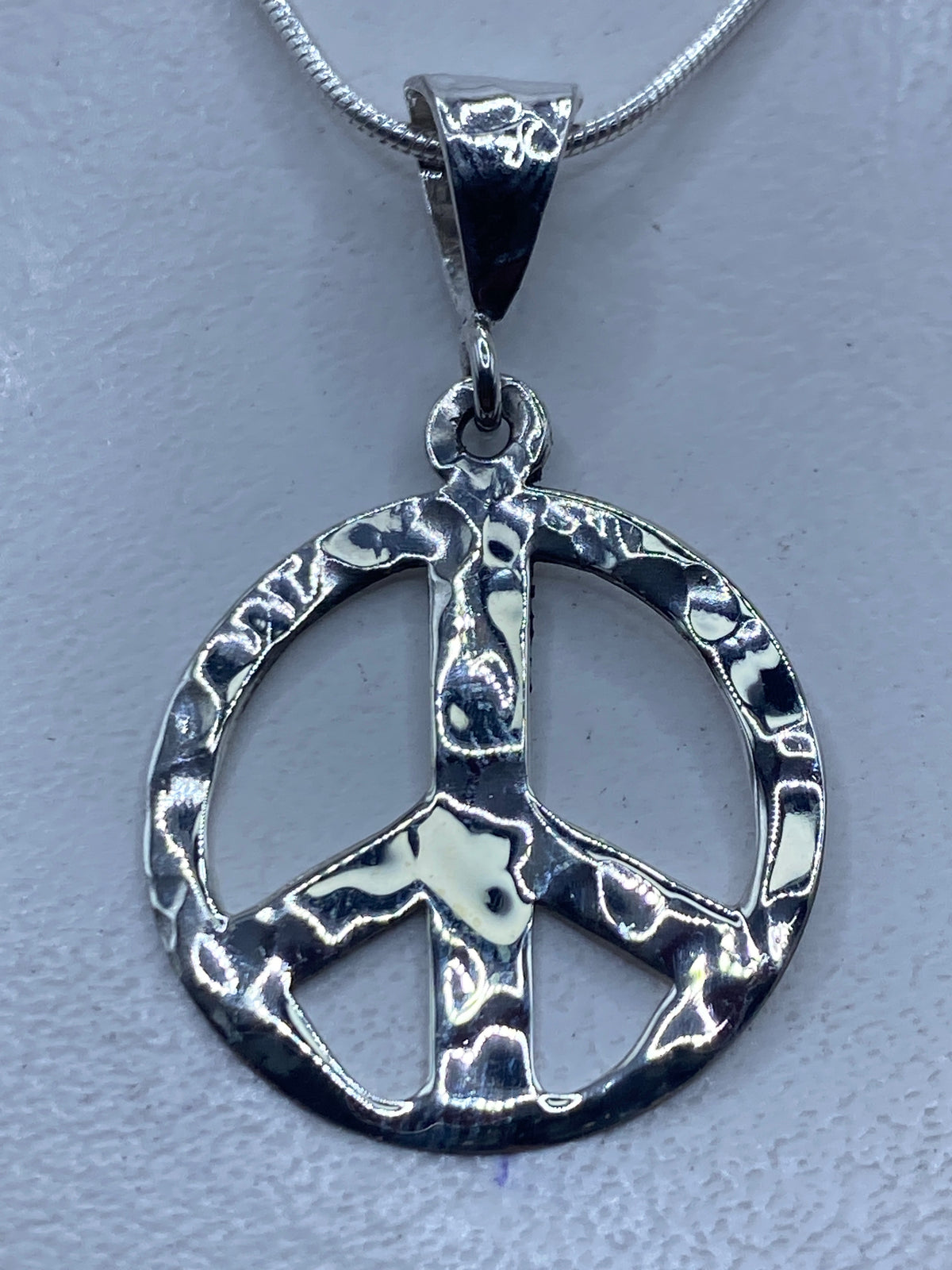Dije símbolo de paz en plata .925 repujado, colgando de cadena de plata