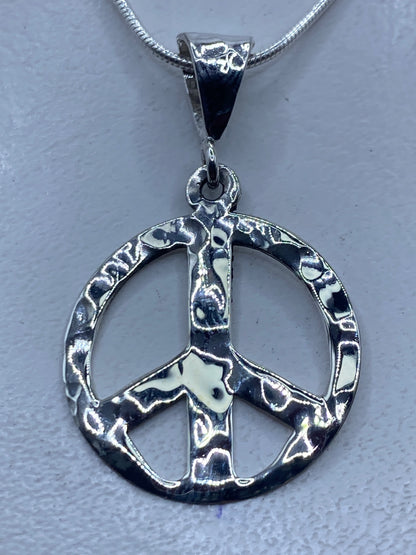 Dije símbolo de paz en plata .925 repujado, colgando de cadena de plata