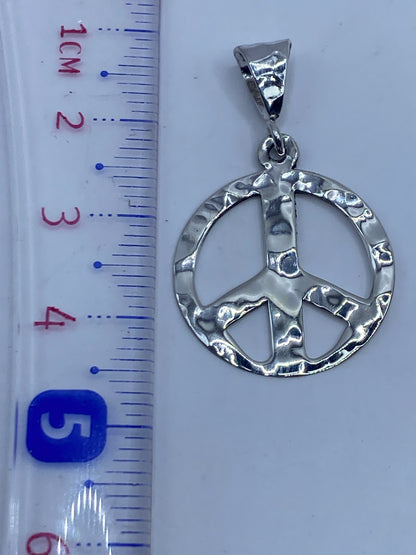 Dije de paz de 4.2 cm en la palma de la mano, escala real