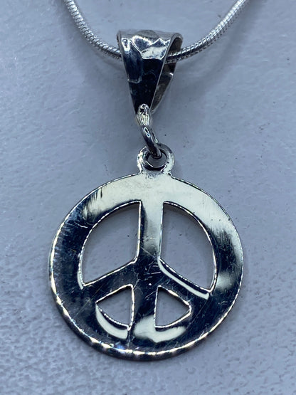 Dije de símbolo de paz en plata .925, colgando de una cadena de serpentina