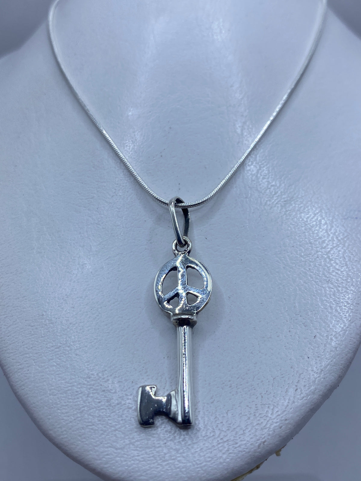Detalle del calado de la llave con símbolo de paz en plata .925