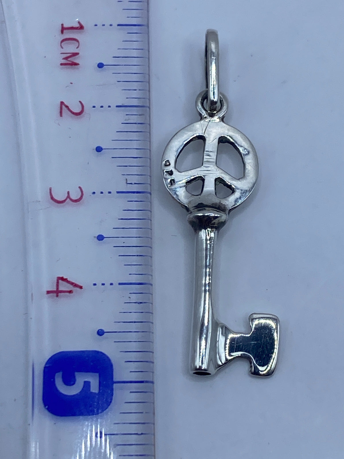 Dije llave sobre fondo blanco con medida de 4.7 cm, Quinto .925 visible