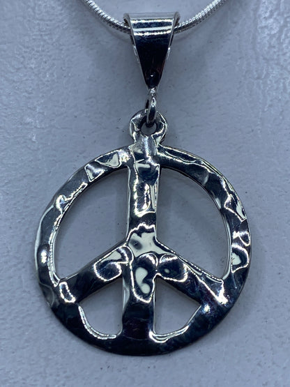 Dije símbolo de paz en plata .925 repujada a mano de Taxco