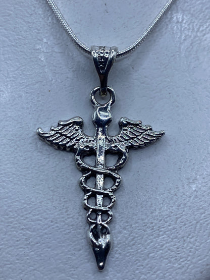 Dije Caduceo de plata .925 colgando de cadena serpentín, mostrando el símbolo médico en relieve