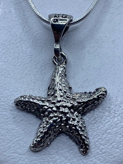 Dije estrella de mar en plata .925 con técnica de granulado, visto de frente mostrando la textura de bolitas soldadas