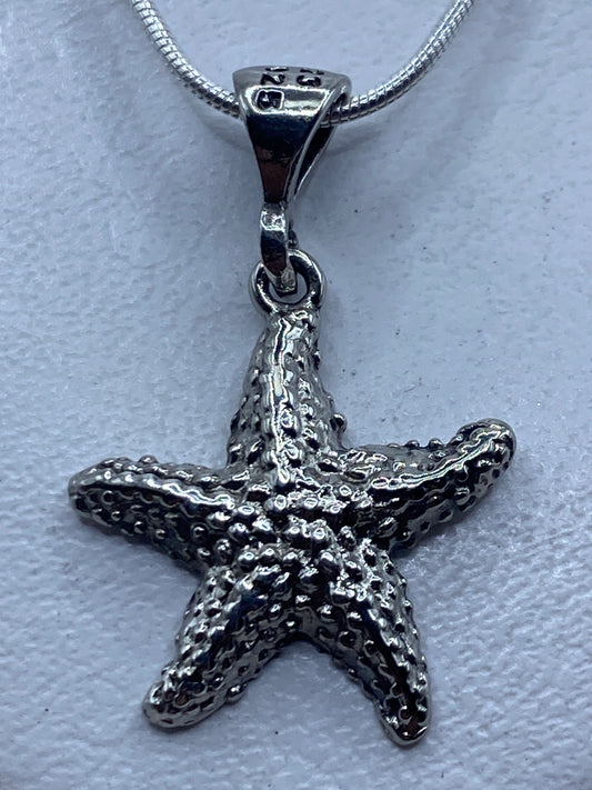 Dije estrella de mar en plata .925 con técnica de granulado, visto de frente mostrando la textura de bolitas soldadas