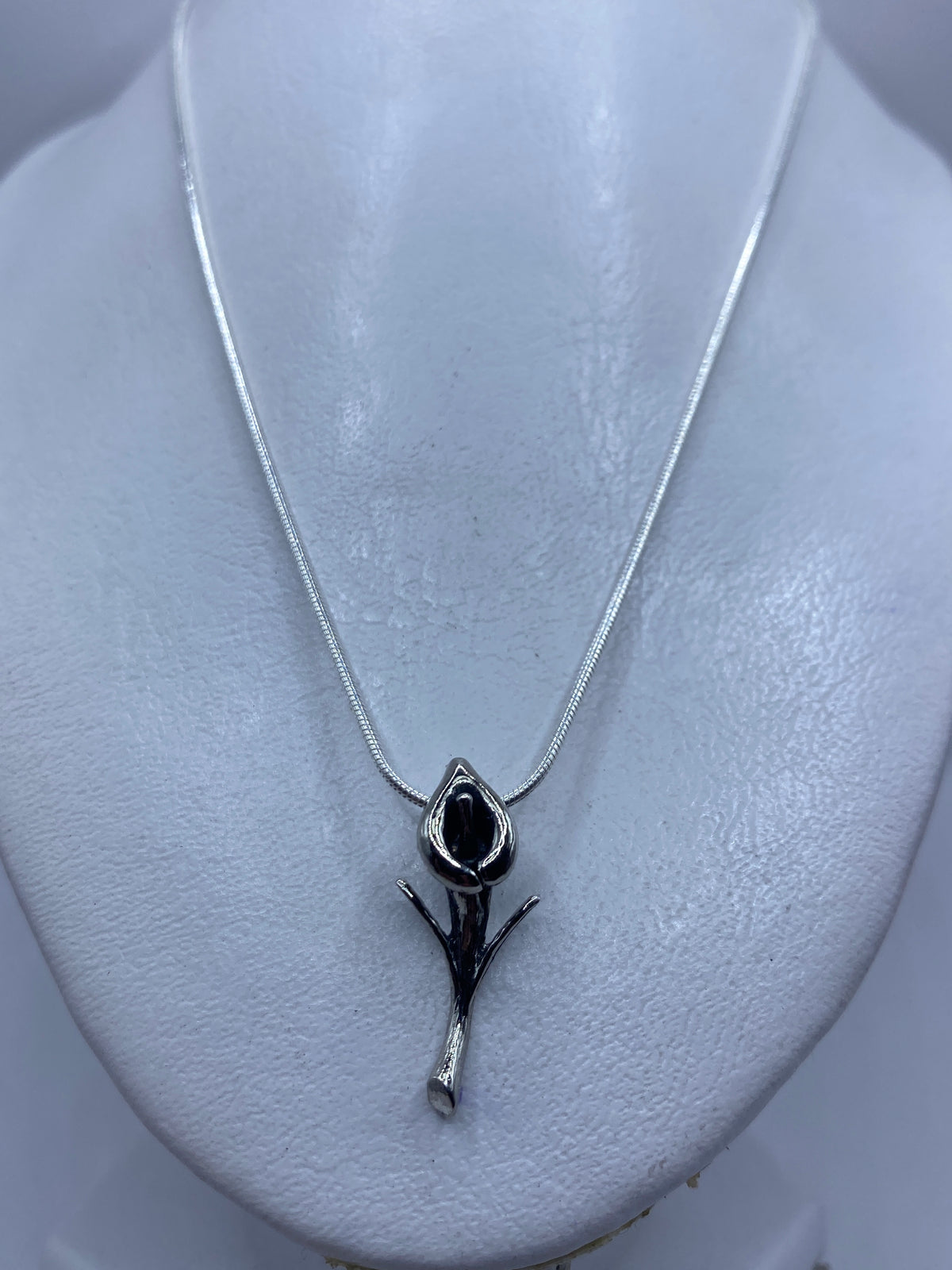 Dije floral de plata .925 de Taxco sobre cuello de maniquí, mostrando tamaño real