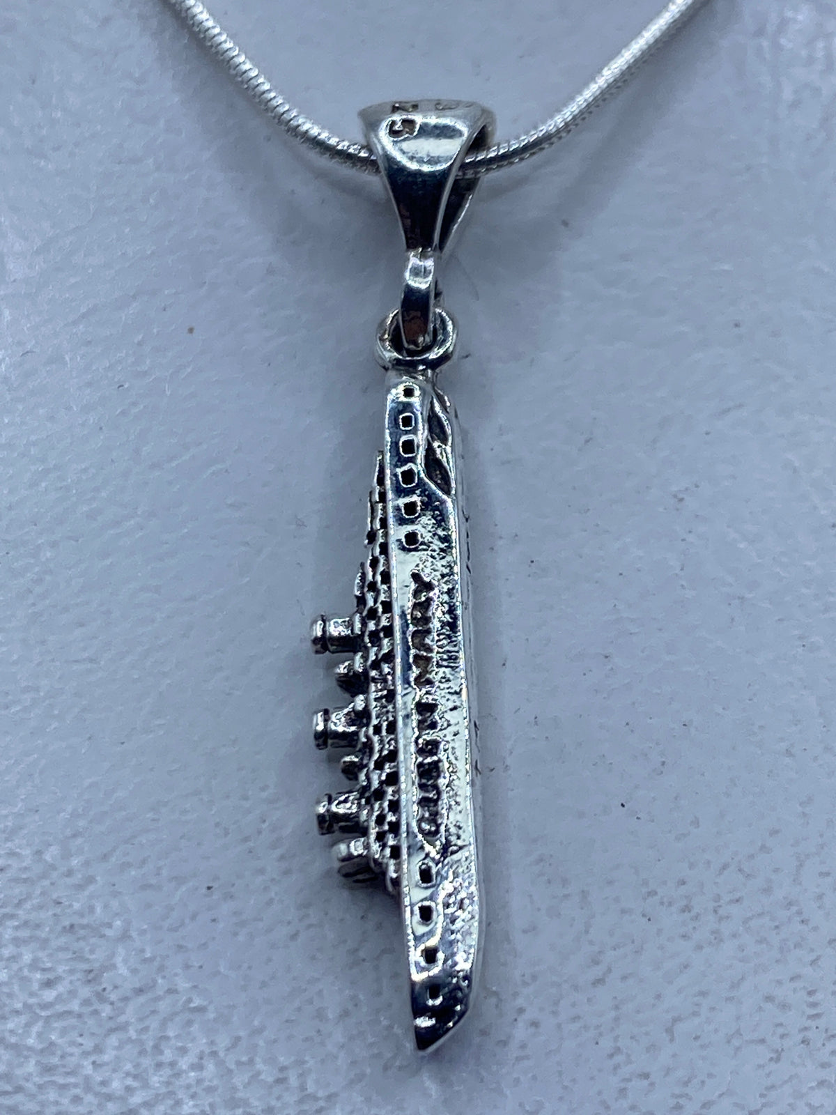 Dije de plata .925 minimalista de 4.3 cm colgando de una cadena de serpentina