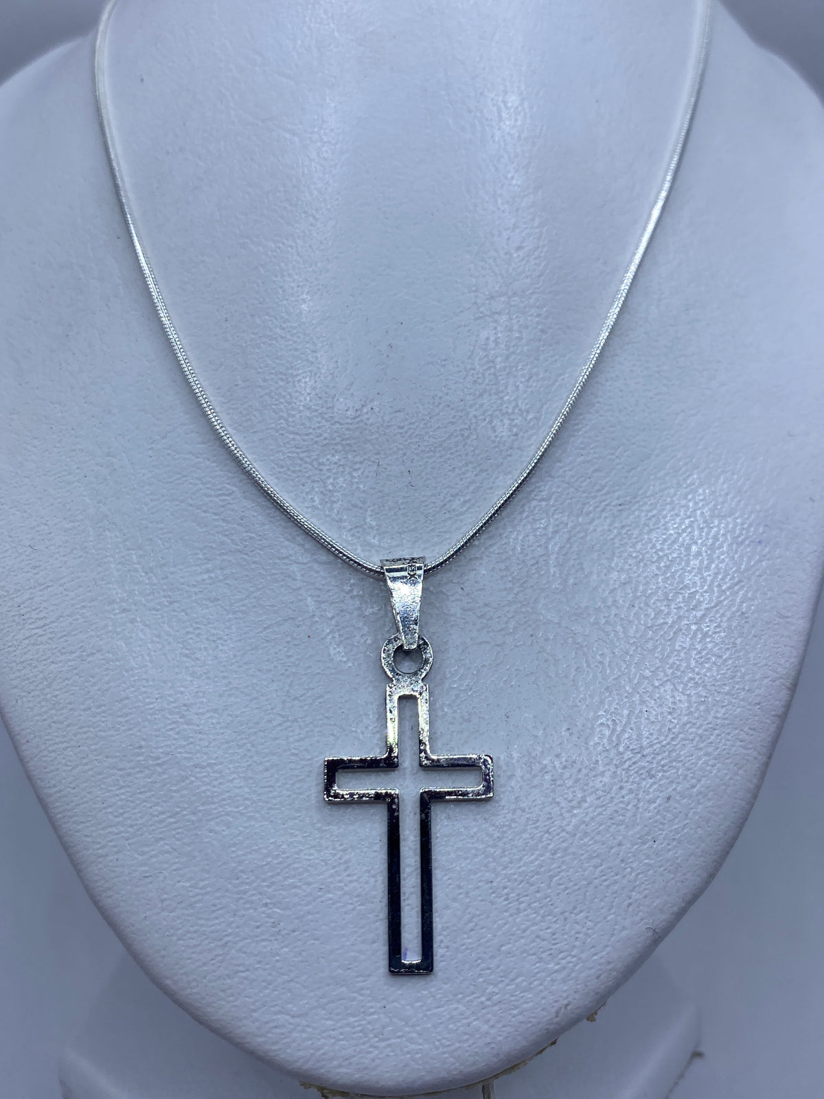 Cruz de plata .925 colgada sobre el pecho, tamaño discreto