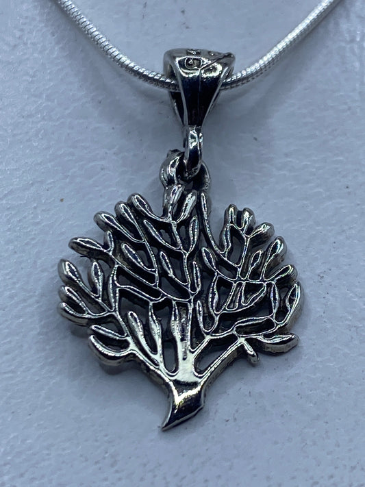 Dije de plata con forma de coral marino ramificado en relieve, colgando de cadena de plata